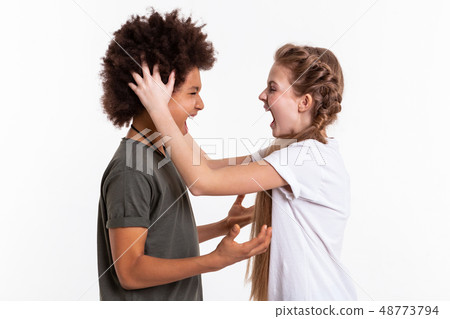Young pretty kids being out of control and screaming on each other Young pretty kids being out of control and screaming on each other 48773794
