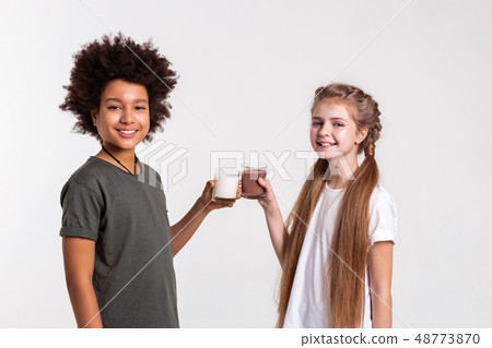 Joyful good-looking young friends holding milk and cacao Joyful good-looking young friends holding milk and cacao 48773870