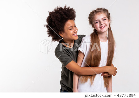 Contented African American boy tightly grabbing his little friend 48773894