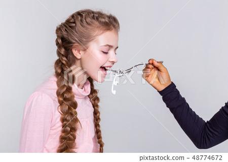 Extraordinary long-haired young girl biting entangled headphones Extraordinary long-haired young girl biting entangled headphones 48774672
