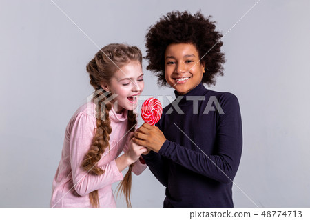Cheerful African American boy playing with long-haired friend 48774713