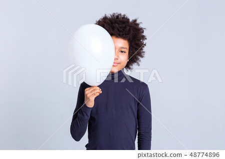 Pretty young man with afro hairstyle closing half of his face with balloon Pretty young man with afro hairstyle closing half of his face with balloon 48774896