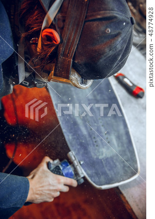 Carpenter using circular saw for cutting wooden boards. 48774928