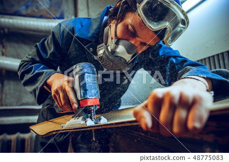 Carpenter using circular saw for cutting wooden boards. Carpenter using circular saw for cutting wooden boards. 48775083