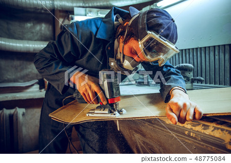 Carpenter using circular saw for cutting wooden boards. Carpenter using circular saw for cutting wooden boards. 48775084