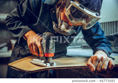 Carpenter using circular saw for cutting wooden boards. Carpenter using circular saw for cutting wooden boards. 48775085