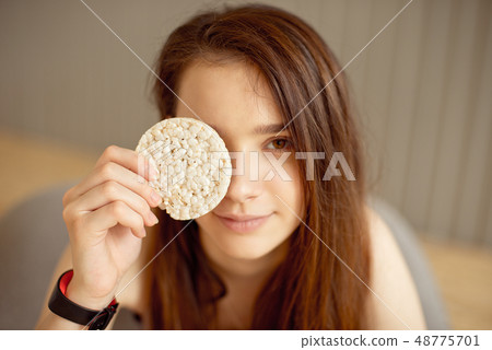 Athletic girl holding crunchy rice cakes, healthy food, healthy lifestyle. Athletic girl holding crunchy rice cakes, healthy food, healthy lifestyle. 48775701