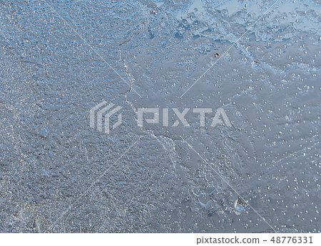 Sun rays caught in cracks in ice piece. Broken 48776331