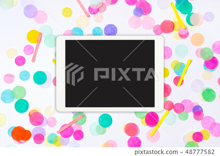 White touchpad with blank screen with colorful confetti. Colorful confetti background with tablet White touchpad with blank screen with colorful confetti. Colorful confetti background with tablet 48777582