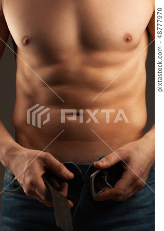 Man unbuckling the belt. Abdominal muscles Man unbuckling the belt. Abdominal muscles 48777970