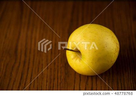 Yellow apple on the wooden vintage background Yellow apple on the wooden vintage background 48778768