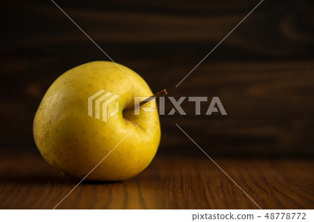 Yellow apple on the wooden vintage background Yellow apple on the wooden vintage background 48778772