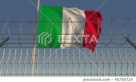 Defocused waving flag of Italy behind barbed wire fence. 3D rendering 48780320
