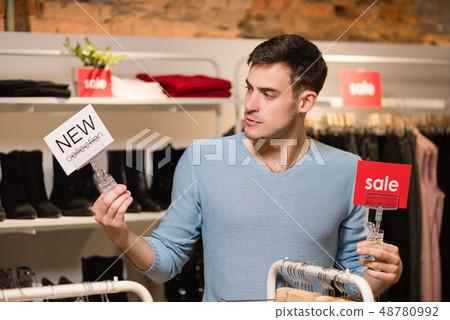 Man with red sale and white new collection tags. 48780992