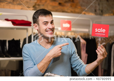 Seller point sale red tag in clothing store. Seller point sale red tag in clothing store. 48780995