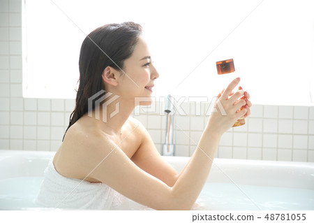 A woman taking a bath A woman taking a bath 48781055