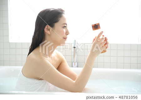 A woman taking a bath A woman taking a bath 48781056