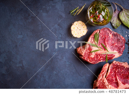 Raw meat steak on rustic concrete background ready to roasting Raw meat steak on rustic concrete background ready to roasting 48781473