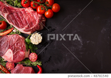 Raw meat steaks on a dark background ready to roasting 48781540