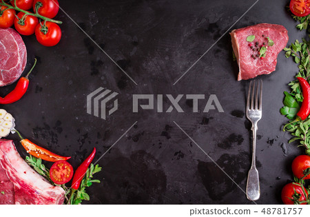 Raw meat steaks on a dark background ready to roasting Raw meat steaks on a dark background ready to roasting 48781757