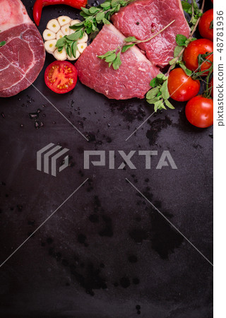 Raw meat steaks on a dark background ready to roasting Raw meat steaks on a dark background ready to roasting 48781936