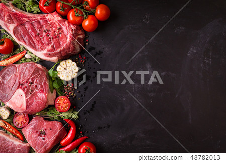 Raw meat steaks on a dark background ready to roasting 48782013