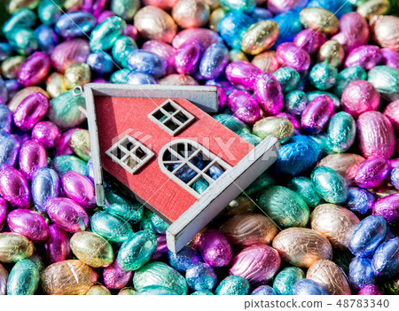 Chocolate Easter eggs and toy house on it Chocolate Easter eggs and toy house on it 48783340