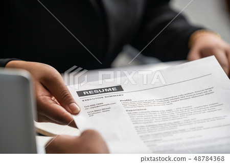 Candidate hands resume to the interviewer. Candidate hands resume to the interviewer. 48784368