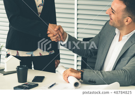 Businessman handshake businesswoman in office. Businessman handshake businesswoman in office. 48784825
