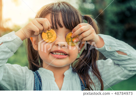 Little girl kid holding bitcoin digital money. Little girl kid holding bitcoin digital money. 48784973
