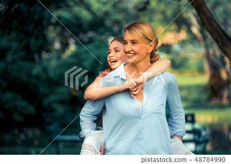 Happy mother and little kid daughter in park. Happy mother and little kid daughter in park. 48784990