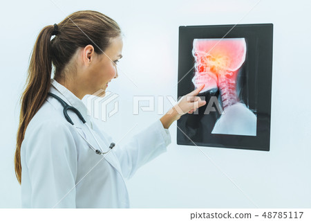 Doctor working with x ray film of patient head. Doctor working with x ray film of patient head. 48785117