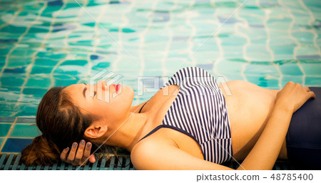 Woman at swimming pool in summer in luxury resort. Woman at swimming pool in summer in luxury resort. 48785400