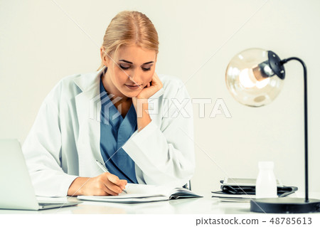 Doctor in hospital working on medical report. Doctor in hospital working on medical report. 48785613