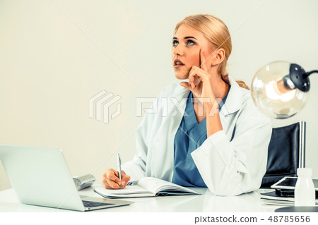 Doctor in hospital working on medical report. 48785656