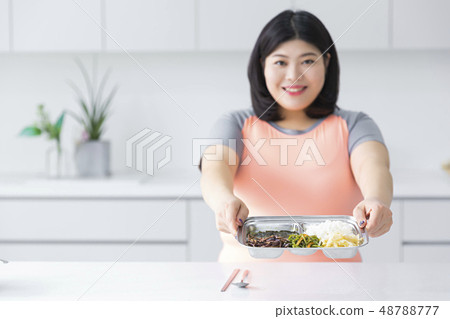 Large girl eating healthy foods and exercise for weight loss, diet concept isolated on gray background 108 Large girl eating healthy foods and exercise for weight loss, diet concept isolated on gray background 108 48788777