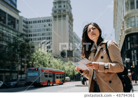 tourist exploring city while holding paper map tourist exploring city while holding paper map 48794361