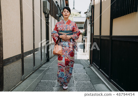 girl walking in path surrounding by old house girl walking in path surrounding by old house 48794454