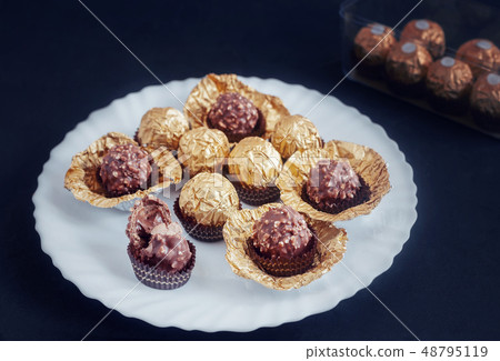 Chocolate candies in a beautiful package of Golden foil. Chocolate candies in a beautiful package of Golden foil. 48795119
