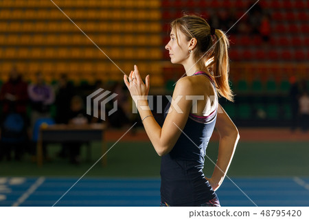 Young slim sportswoman starting long jump attempt Young slim sportswoman starting long jump attempt 48795420