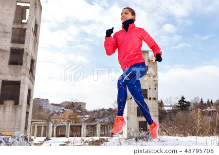 Young slim woman running outdoors in winter 48795708