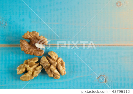 Walnut kernels on a blue wooden background. 48796113
