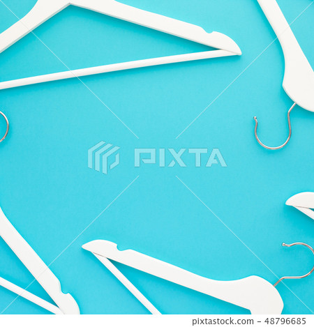 White wooden hangers on blue background White wooden hangers on blue background 48796685