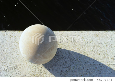 Concrete ball with shadow on the waterfront Concrete ball with shadow on the waterfront 48797784