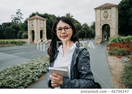 student holding books and looking at camera student holding books and looking at camera 48798347