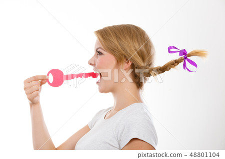 Teenage girl with braid biting key Teenage girl with braid biting key 48801104
