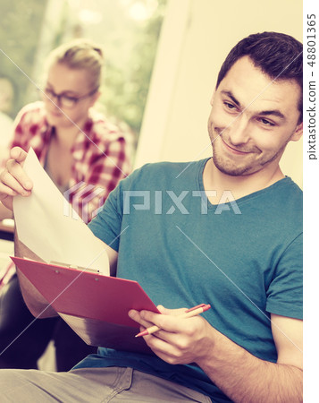 Student guy in front of her mates in classroom 48801365