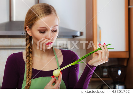 Woman in kitchen holds green fresh chive 48801792