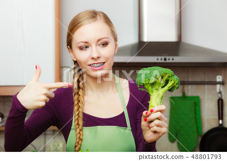 Woman in kitchen with green fresh broccoli 48801793