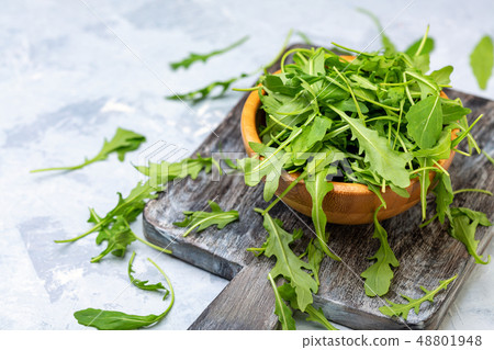 Arugula leaves in a wooden bowl. Arugula leaves in a wooden bowl. 48801948